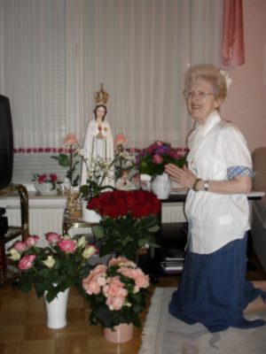 Anne knieend vor der Mutter Gottes umgeben von Blumen